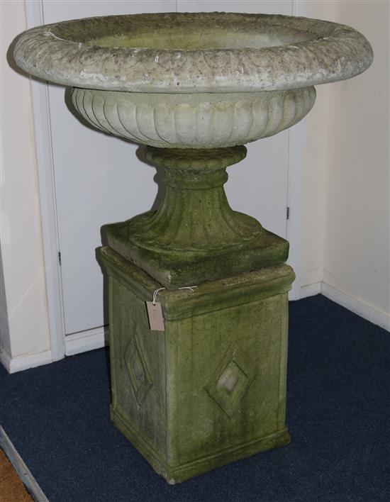 A large circular stone garden urn on fluted and square plinth base, H.105cm